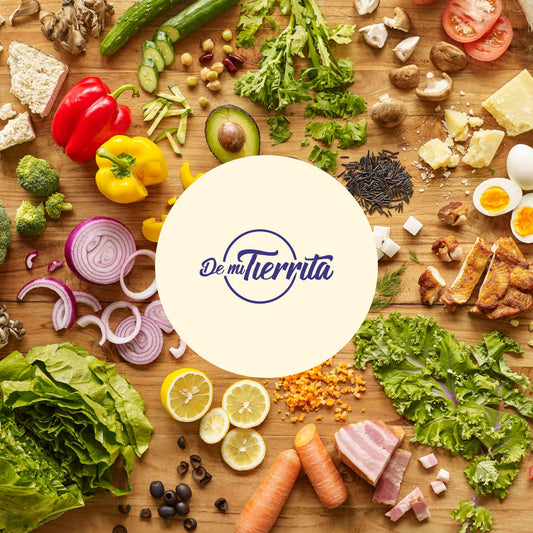 Logo de la marca 'De mi Tierrita' sobre un fondo de ingredientes frescos y naturales como vegetales, legumbres, frutos secos, hierbas y productos típicos de la cocina colombiana, representando la diversidad, frescura y sabor artesanal de los productos de la tienda.
